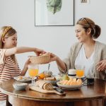 A warm family breakfast with mother and daughter sharing a meal in a cozy dining area.